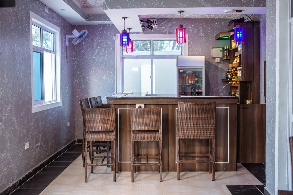 The bar counter at Cherinas Homes, with high stools and stocked shelves.